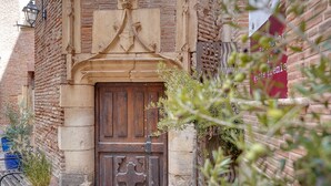 Un bâtiment rustique avec une porte en bois, des murs en pierre et des plantes en pot.