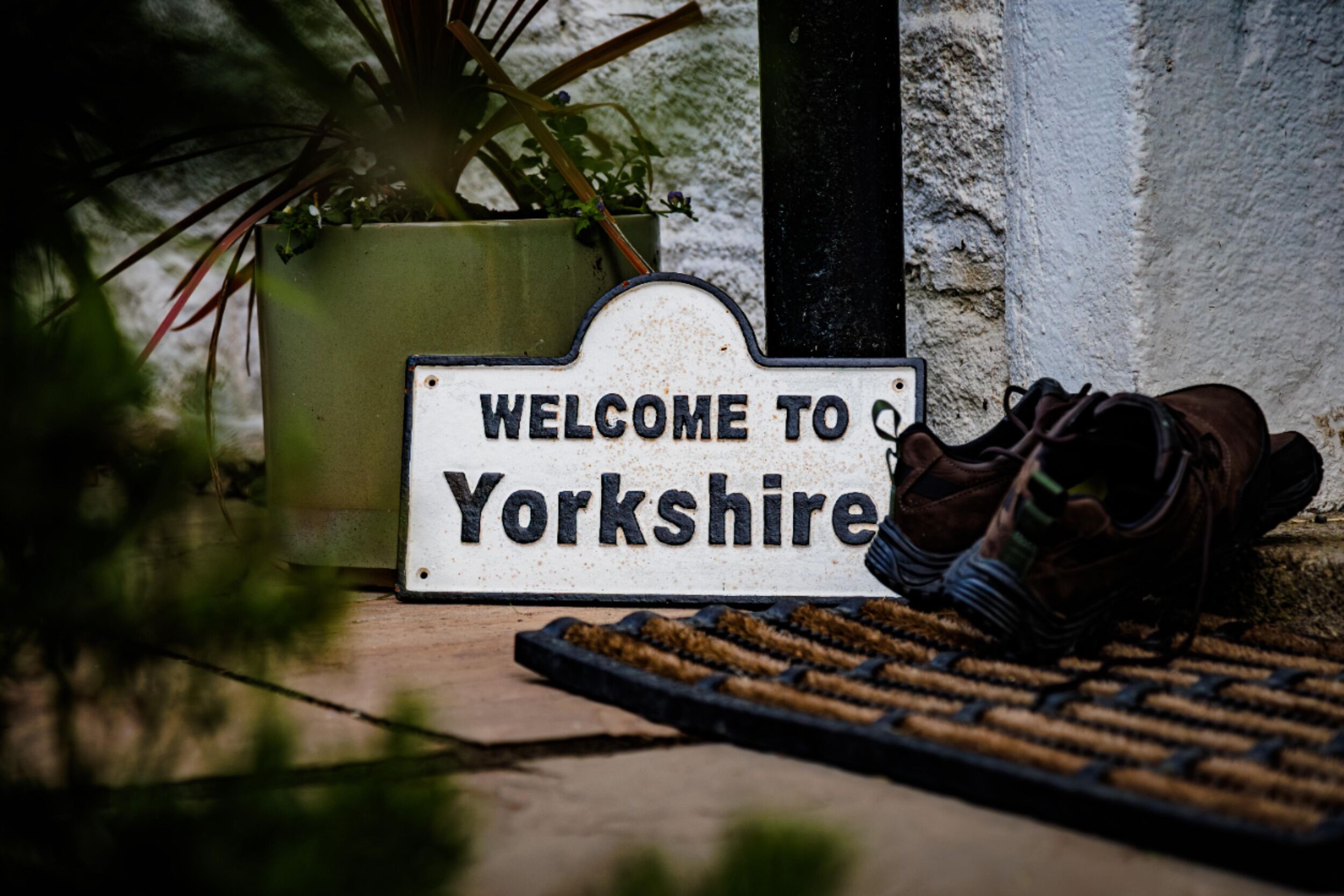 Un panneau d’accueil indiquant l’entrée dans le Yorkshire, avec une paire de chaussures posée sur le sol.