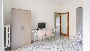 A small room with a desk, two chairs, a computer, a radiator, and a wardrobe. - Casa Campione by Wonderful Italy (Bari)