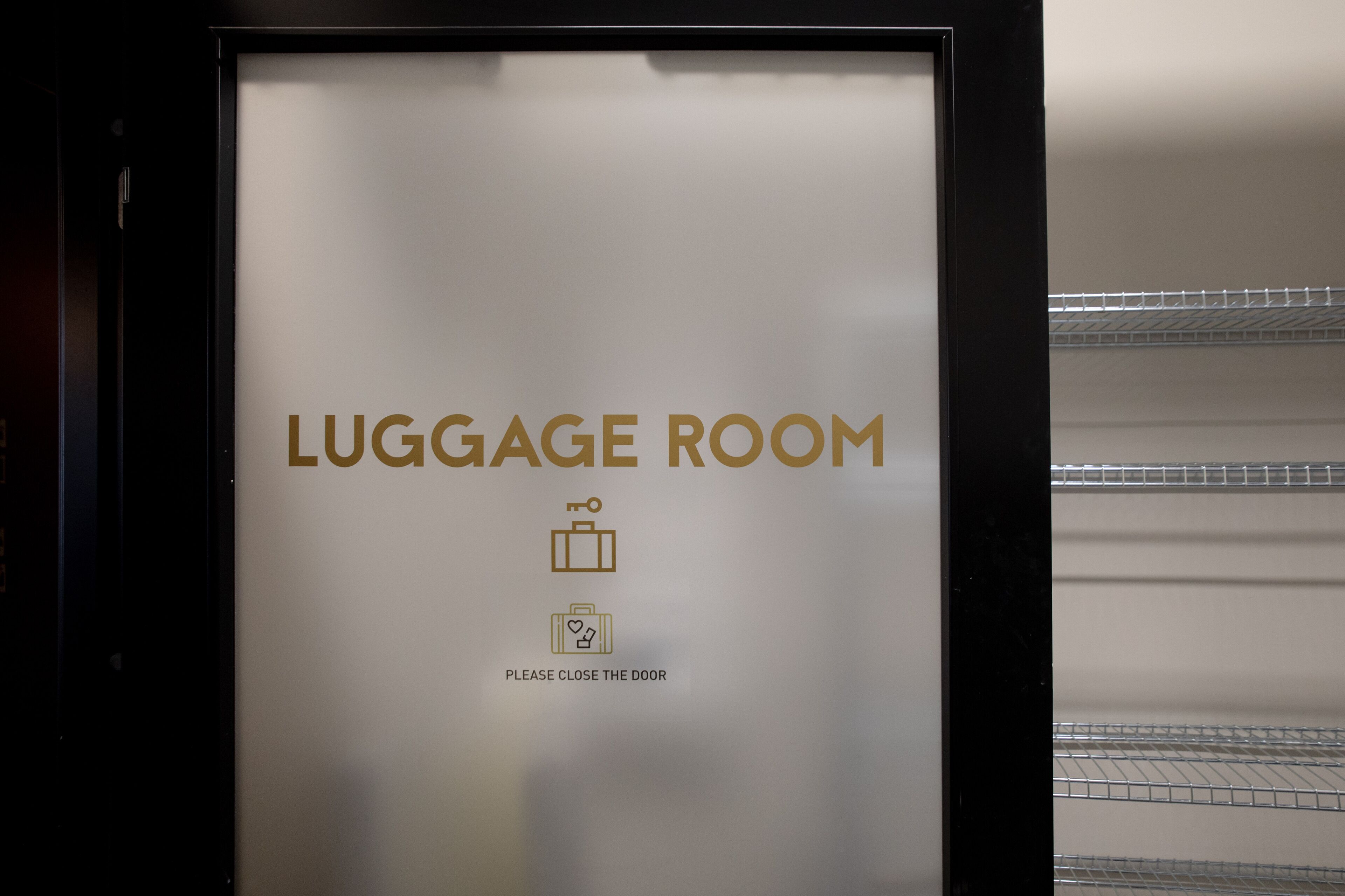 A sign indicating a luggage room with a suitcase icon and a heart icon, and a message to close the door.