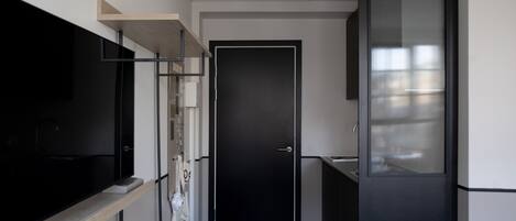 Una cocina moderna con un refrigerador negro, una encimera de madera y una puerta negra.