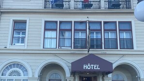 A hotel with a classic facade, multiple windows, and a prominent 'HOTEL' sign above the entrance. - Hotel Terrasse Dufferin (Québec City)