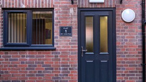 Une porte noire avec une plaque indiquant « APPARTEMENT 1, 59C, London Road ».