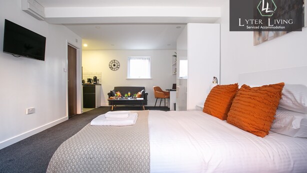 Une chambre d’hôtel avec un lit, un bureau, une chaise et un téléviseur.