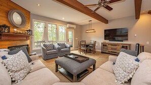 A spacious living room with a fireplace, two sofas, a coffee table, and a TV.