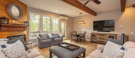 A spacious living room with a fireplace, two sofas, a coffee table, and a TV.