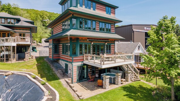 Un immeuble à plusieurs étages doté d’une terrasse, d’un espace salon extérieur et d’un jacuzzi.