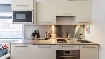 A modern kitchen with a built-in microwave, stove, sink, and dishwasher.