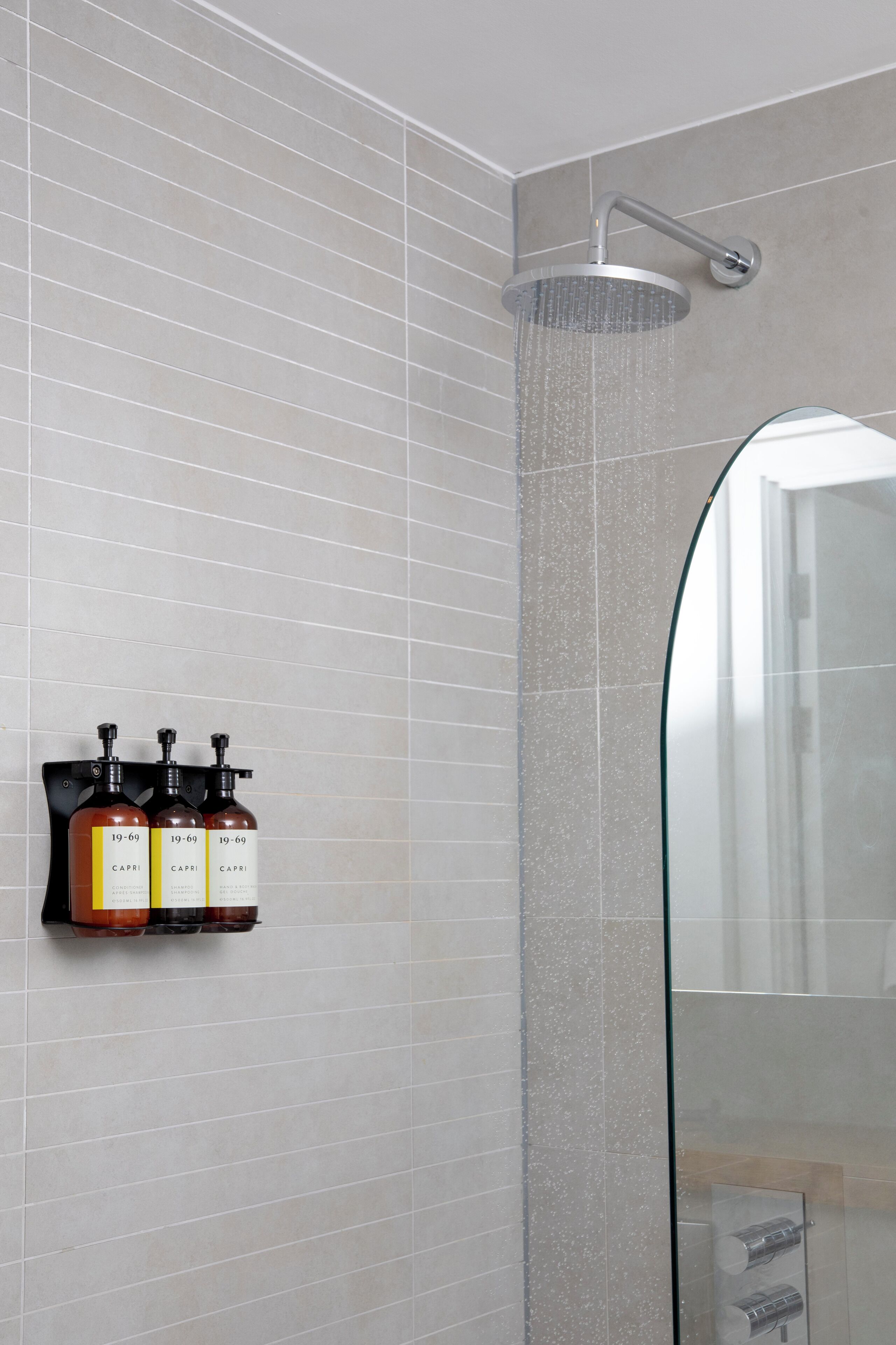 Ein modernes Badezimmer mit Dusche, Glasabtrennung und Wandseifenspender.