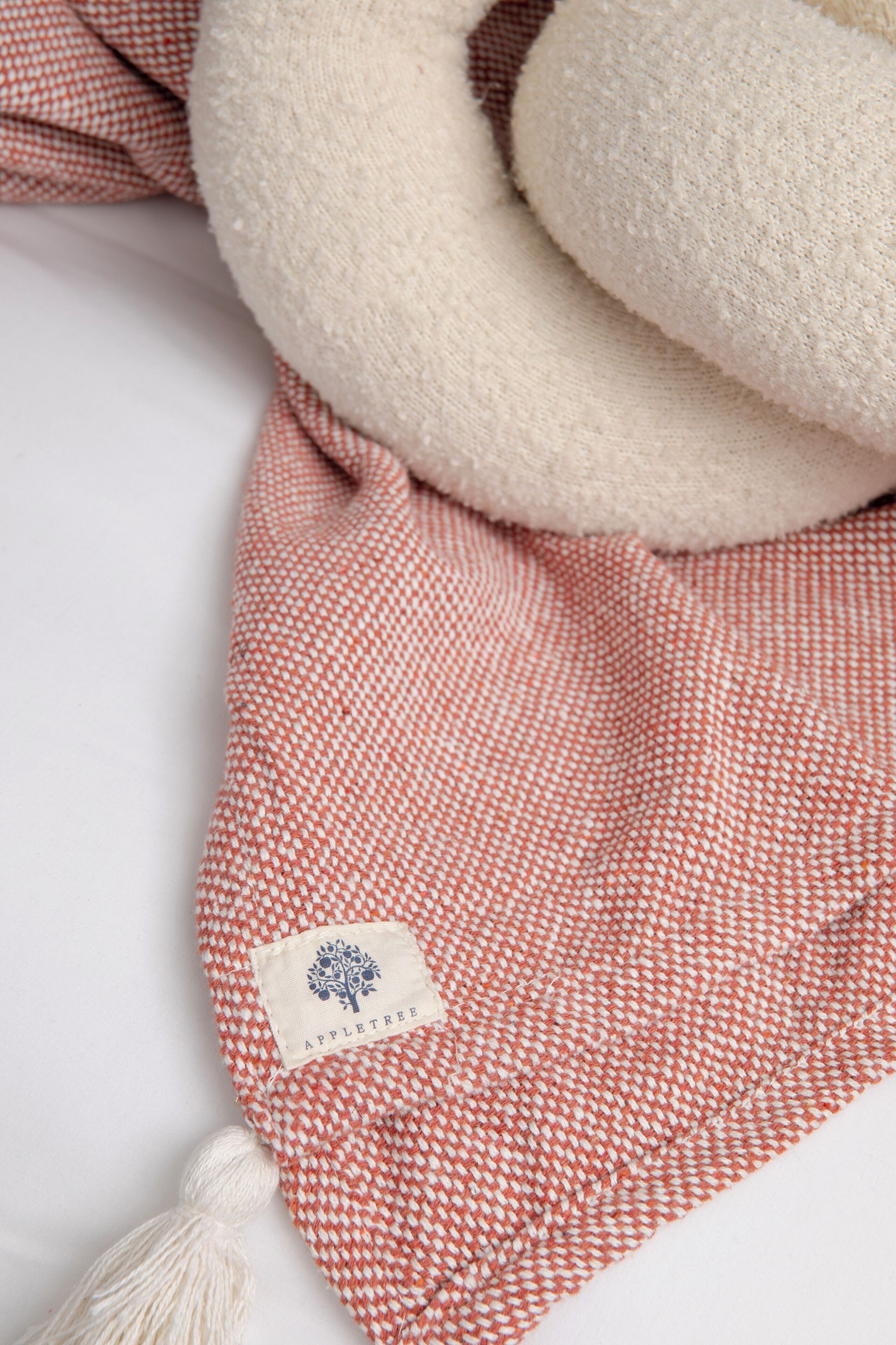 A neatly folded red and white checkered towel with a white label and a white tassel.