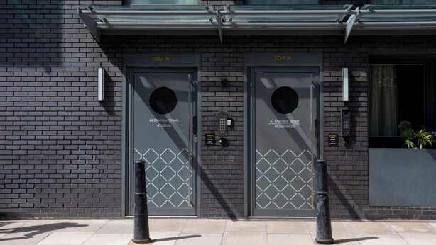A building with two doors labeled "808 W. 66 Chamber Street Studios" and "808 W. 67 Chamber Street Residences". - Bob W London Tower Hill  - Residences (London)