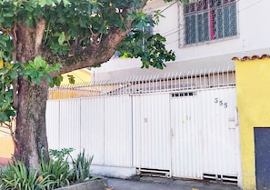 Un espace clos, avec un arbre et un bâtiment en arrière-plan.
