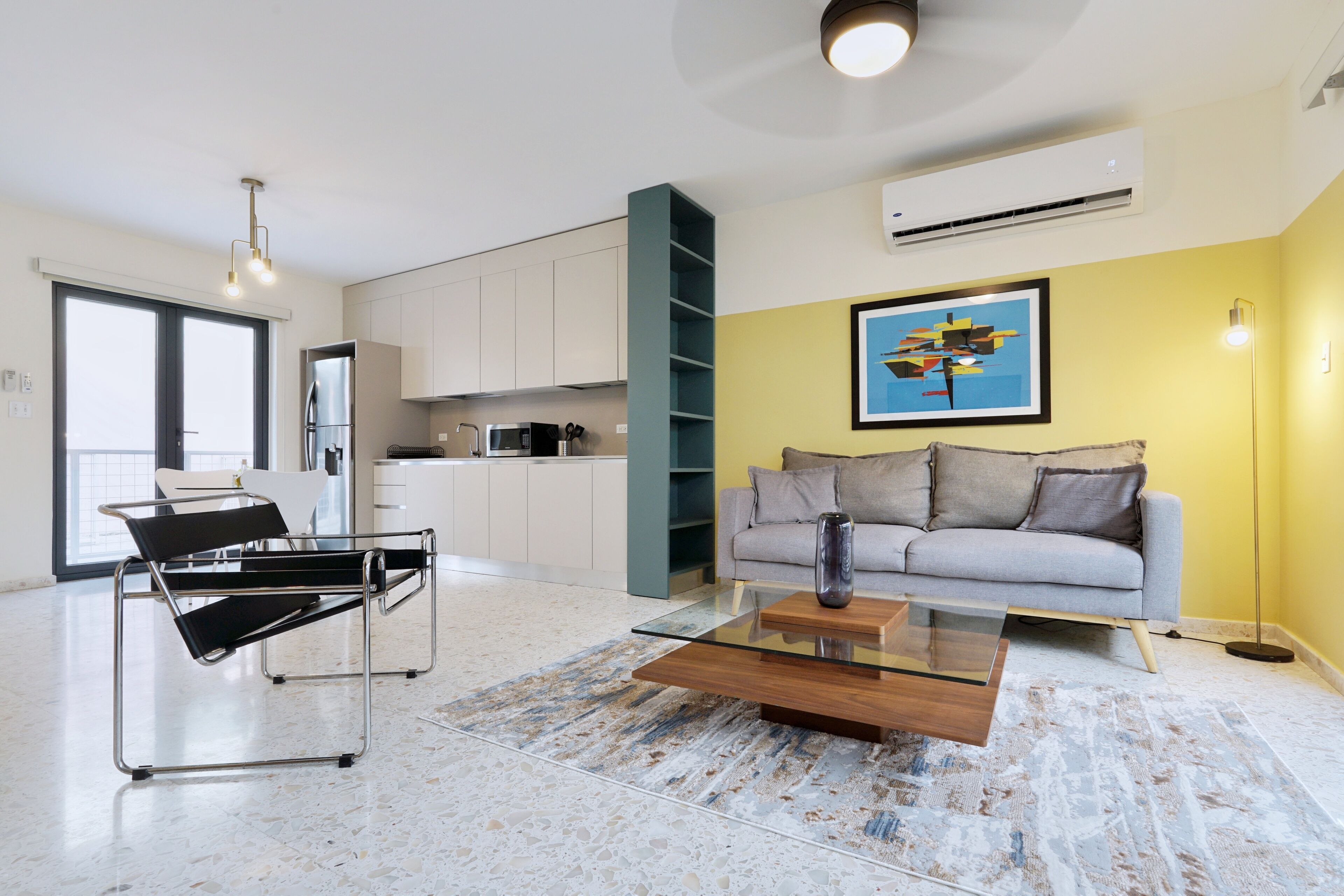 Un appartement moderne doté d’une cuisine, d’un espace de vie et d’une grande fenêtre.