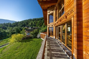 A wooden building with a balcony overlooking a green landscape and a mountain. - Chalet Vansamis, views & sauna (Haute-Nendaz)