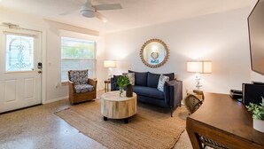 Ein Wohnzimmer mit Sofa, Sessel, Couchtisch und Esstisch.