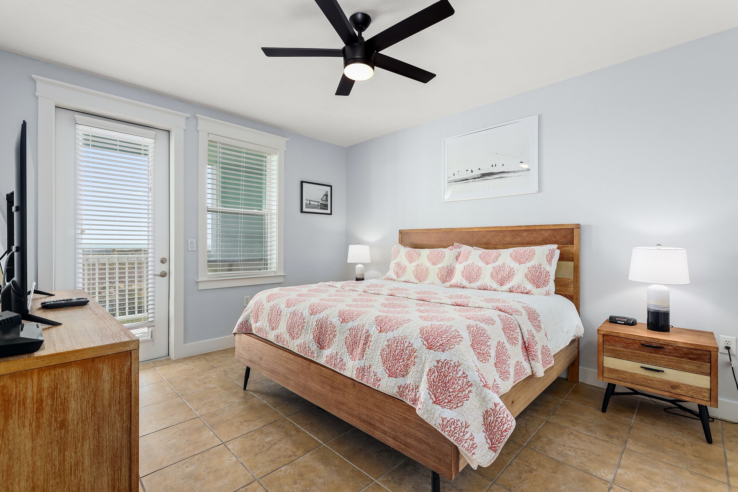 A bedroom with a bed, bedside tables, a ceiling fan, and a window with blinds.