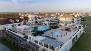 Een resort met meerdere gebouwen, een groot zwembad en een steiger.