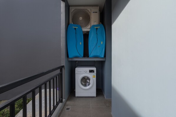 A laundry area with a washing machine and two blue drying racks. - Studio at Relife by TropicLook (Rawai)