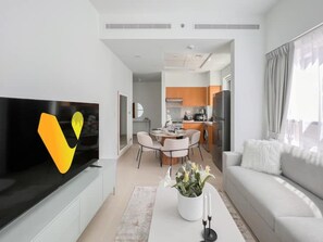 Relax in this stylish living room with a flat-screen TV, comfortable sofa, and dining area.