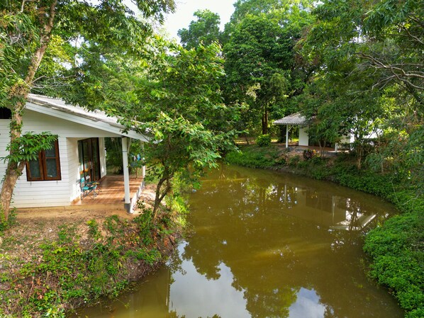 A riverside property with a covered porch and a small pavilion.