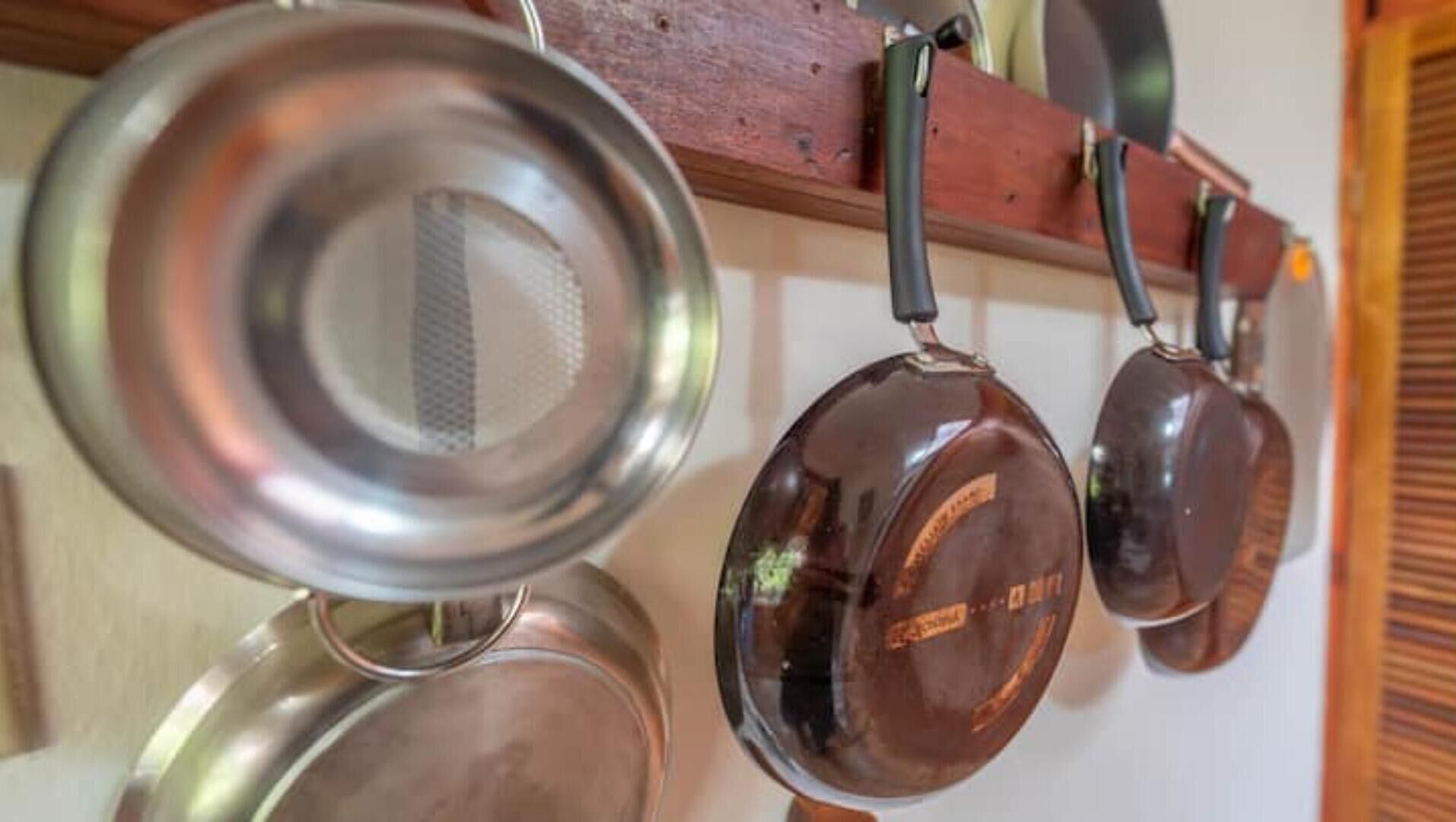 A kitchen with hanging pots and pans.