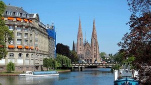 A river with a boat and a historic church in the background.