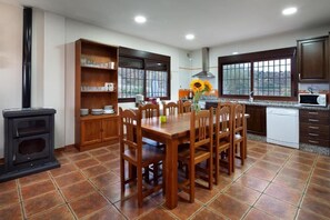 Une cuisine équipée d’une table à manger, de chaises, d’une cuisinière et de placards.