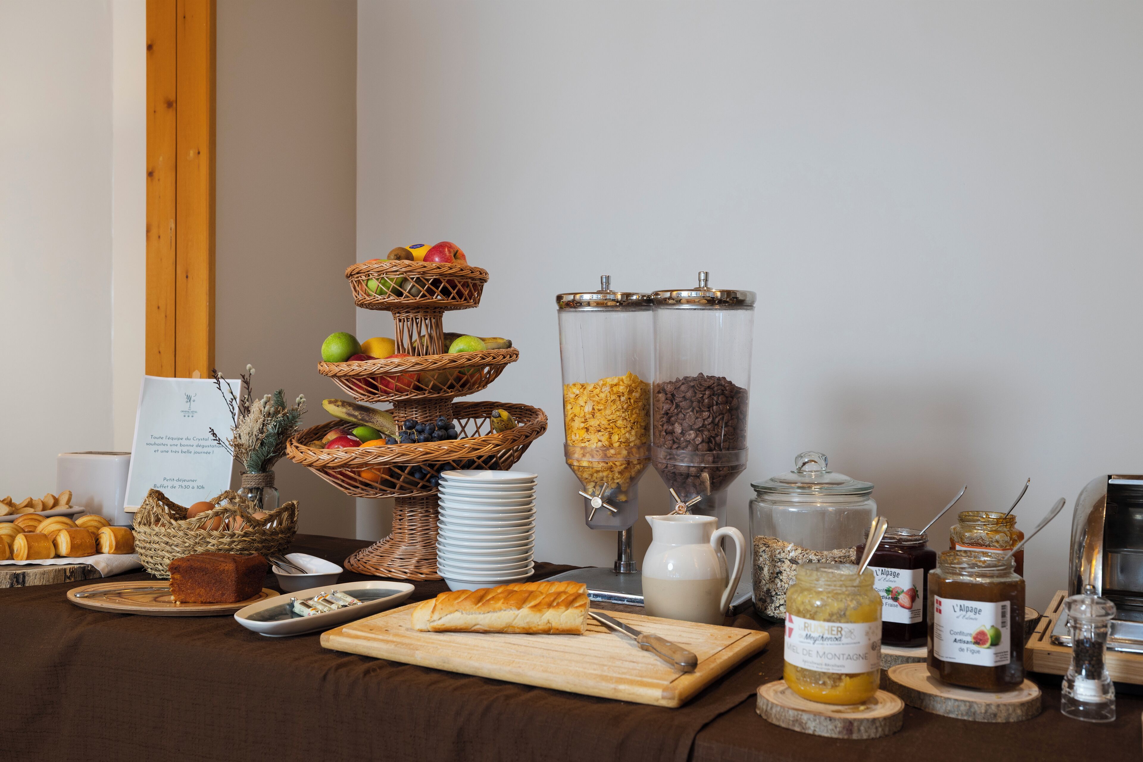 A breakfast buffet with various food items, including fruits, pastries, and condiments.
