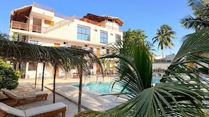 A resort with a pool, palm trees, and sun loungers. - Mexhe Hotel Boutique (El Cuyo)