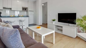 Ein zeitgemäßer Wohnraum mit Küche, Essbereich und Flachbildfernseher.