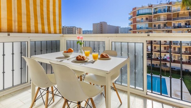 A balcony with a table set for breakfast, including croissants, orange juice, and a bowl of fruit. - Erisa 1, 68 - Terrace, Swimming Pool, Parking, Second line of beach. 1 bedroom (Torremolinos)