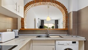 Eine moderne Küche mit Einbauwaschmaschine, Spüle und Toaster.
