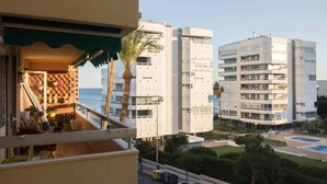 A balcony with a view of a modern building complex, a pool, and a clear sky. - Tropico - Beachfront, 1 bedroom, Carihuela (Torremolinos)