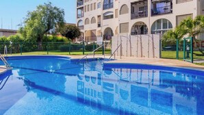 A swimming pool with a clear view of the surrounding buildings and a fenced area. - Imperial Puerto 3E - Terrace, Swimming Pool, 200m from the beach (Torremolinos)