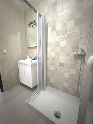 Chuveiro, secador de cabelo, toalhas de banho, sabonete