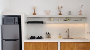 A modern kitchen with a stainless steel refrigerator, a built-in microwave, a gas stove, wooden cabinets, and a white countertop. - Splendid Villa Eden White Canggu Pool & 2 Bd (Canggu)