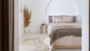A bedroom with a bed, a bedside table, a lamp, and a plant. - Splendid Villa Eden White Canggu Pool & 2 Bd (Canggu)