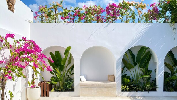 A pool area with a white wall, three arches, and potted plants. - Splendid Villa Eden White Canggu Pool & 2 Bd (Canggu)