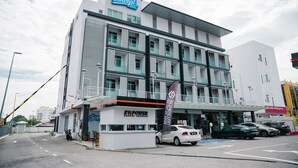 A modern hotel with a prominent sign, multiple floors, and a parking area with cars. - The Concept Hotel Melaka City (Malacca City)