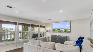 A spacious living room with a large window offering a view of the ocean and a balcony. - 5BR Waterfront Retreat with Pool, Boat Slips + Dock | Boater’s Dream House (Destin)