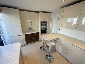 Geladeira, micro-ondas, fogão, mesas de jantar