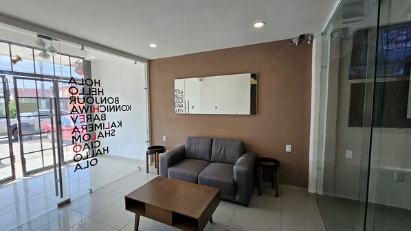 Enjoy easy access to the outdoors from the large glass door, relax on the comfortable sofa, and admire the room's reflection in the large mirror.
