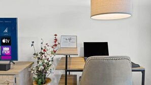 Un espace de bureau moderne comprenant un bureau, une chaise et une grande lampe.