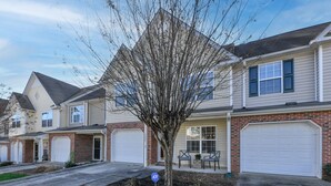 A residential area with houses featuring brick facades and white garage doors.