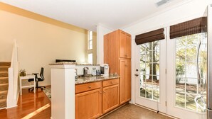 A kitchen with wooden cabinets, a countertop, and a coffee maker.