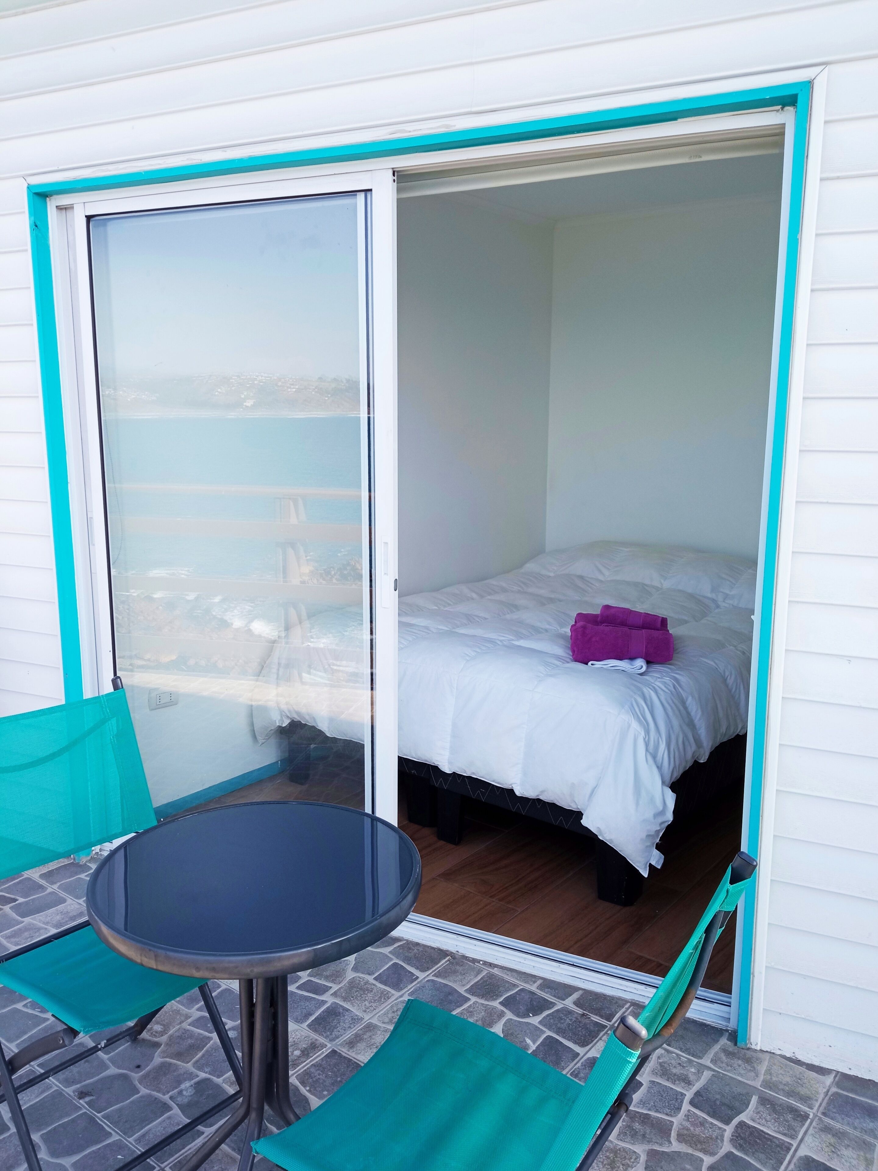 Una habitación con cama, una mesa y una silla.