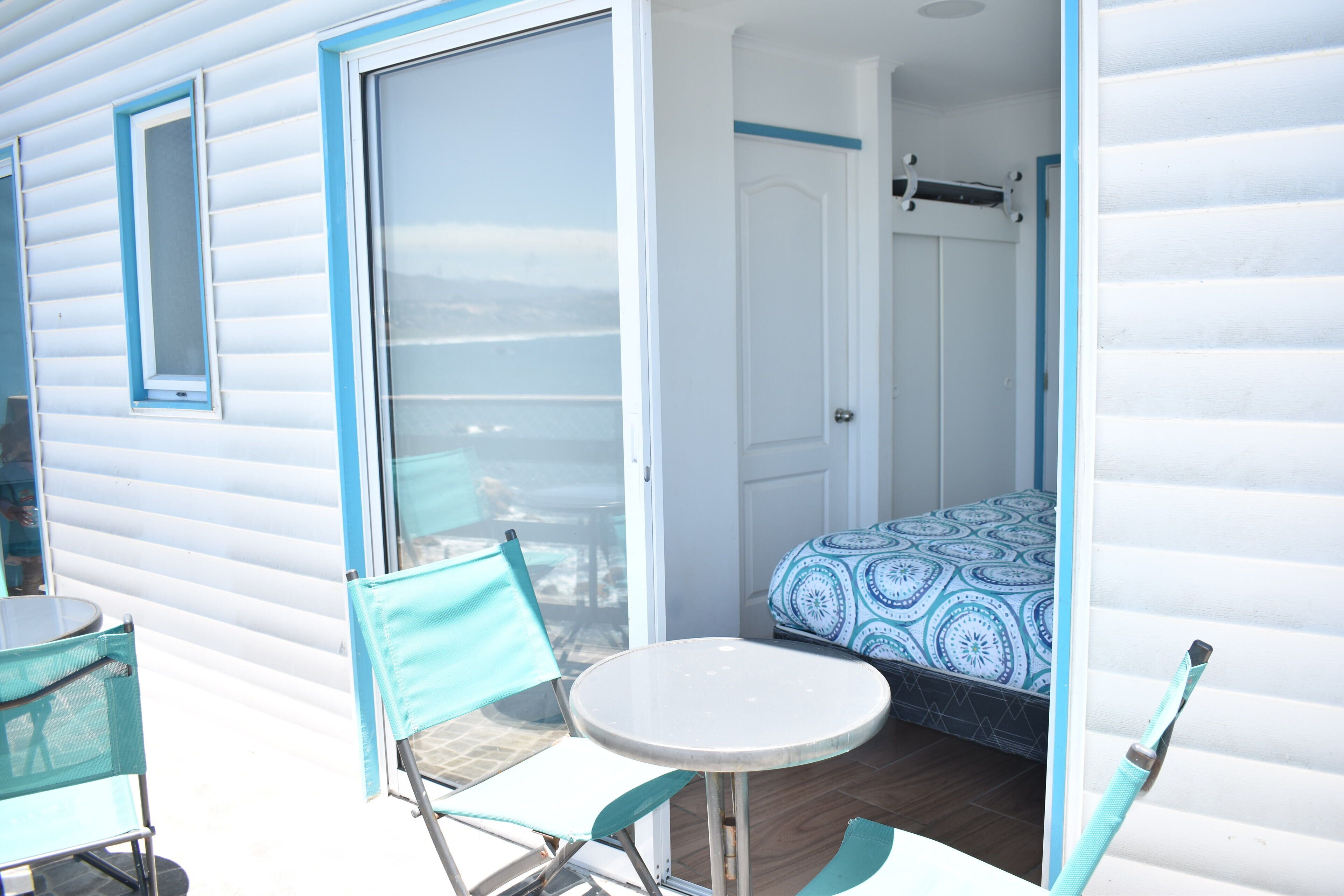 A room with a bed, a table, and two chairs.