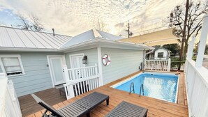 A backyard with a swimming pool, wooden deck, lounge chairs, and a white fence. - SWEET HOUSTON 14 people, 4 Bethrooms, 2 Full Bath. Pool, Central Houston. (Houston)
