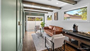 A spacious living area with a brown leather sofa, a glass coffee table, and a dining table with chairs. - Casa 22 Luxury & Modern 3BD 2BA Home in Skokie (Skokie)