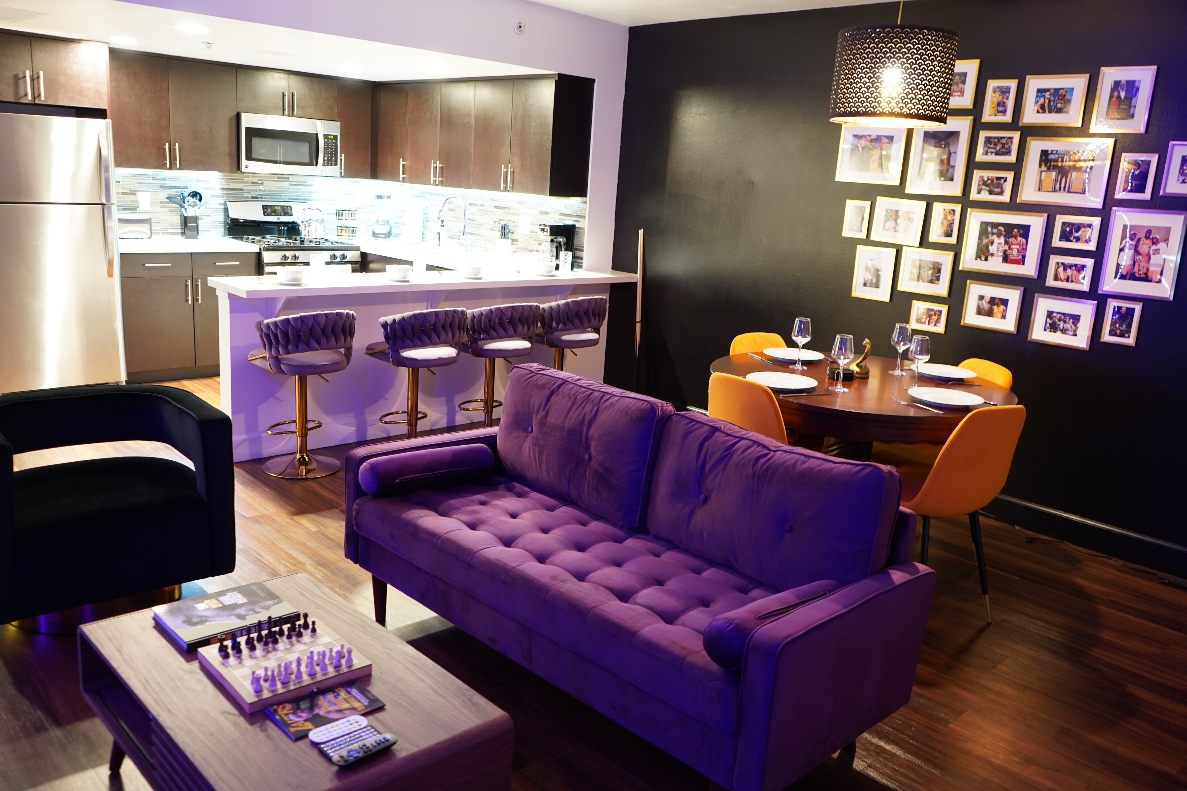 Una cocina moderna con armarios oscuros, una isla central y taburetes de bar.